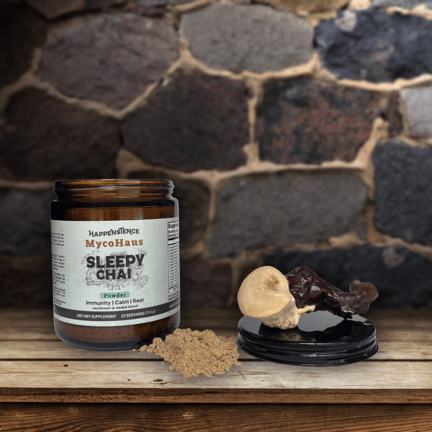 Jar of Happenence MycoHaus Sleepy Chai on a wooden surface with a stone wall background