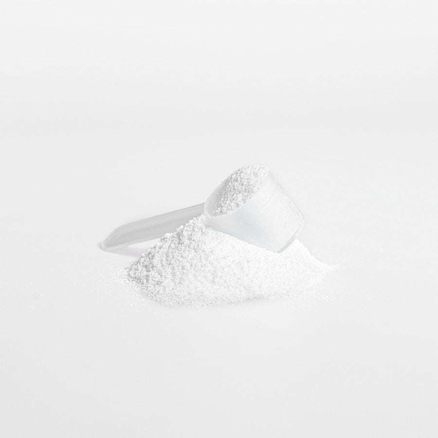 White Creatine powder in a measuring spoon on a white background