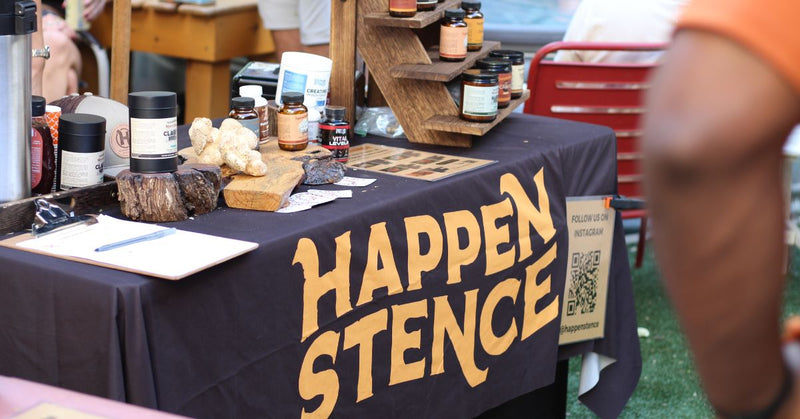 Table with 'Happen Stence' branding at an outdoor event