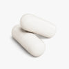 Two white magnesium capsules on a light gray background